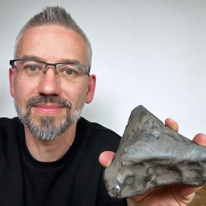 Prof. Szymon Kozłowski presents a new meteorite. Source: Astronomical Observatory UW